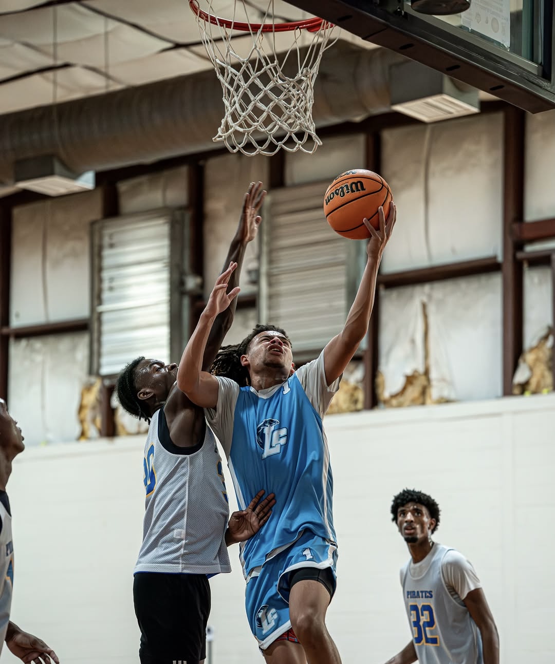 Long County High School guard Jy'Son Mallard finishes at the rim over a defender during a Class of 2027 South Georgia basketball game.